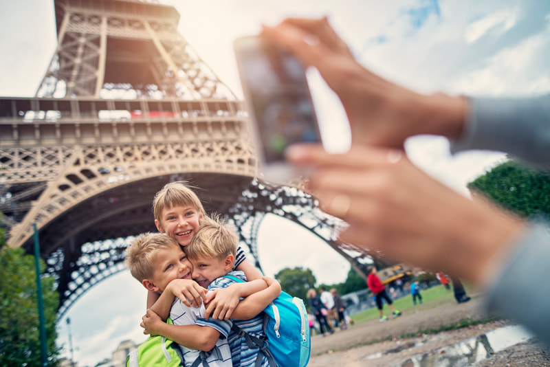 three kids hugging in front of eiffel tower